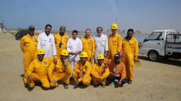 Field training group in yellow coveralls at a coastal site