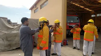 Participants putting on fire-fighting protective equipment
